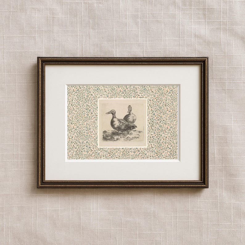 May include: Framed artwork featuring a detailed black and white illustration of two ducks. The artwork is set against a patterned background with a white mat and a dark brown frame. The overall aesthetic is vintage and nature-themed.