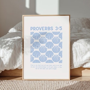 May include: A framed print with the text "PROVERBS 3:5" in light blue. The print features a pattern of light blue seashells on a white background. The text "Trust in the Lord..." is below the seashell pattern.