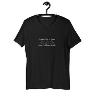 Puede incluir: Camiseta negra con el texto "From Cradle to Tomb, From Coffin to Womb." El texto es blanco y morado. La camiseta está colgada en una percha negra.
