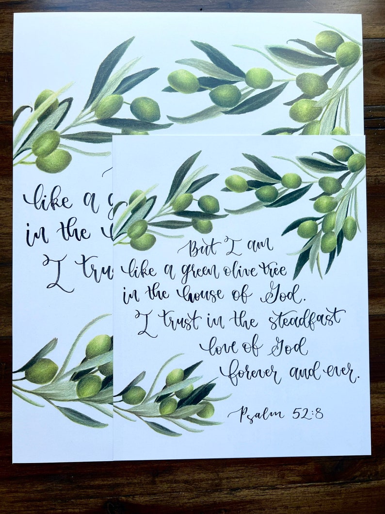 May include: A white background with a green olive branch and a handwritten quote from Psalm 52:8. The quote reads "But I am like a green olive tree in the house of God. I trust in the steadfast love of God forever and ever. Psalm 52:8".