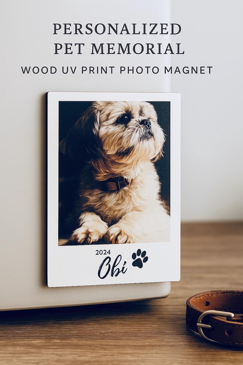 May include: A white wooden photo magnet with a picture of a small, light brown dog. The magnet has a paw print and the text "2024 Obi" printed on it.