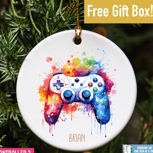 May include: A white ceramic Christmas ornament with a colorful watercolor design of a video game controller. The name "BRIAN" is printed below the controller.