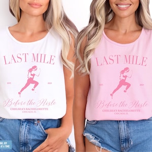 May include: White and pink tank tops with the text "LAST MILE" and a running figure graphic. The text "Before the Nistle" and "Chelsea's Bachelorette Chicago, IL" are also printed on the shirts. The tank tops are sleeveless.