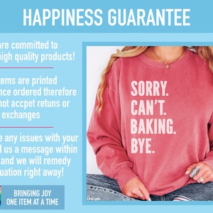 May include: A pink sweatshirt with the text "SORRY. CAN'T. BAKING. BYE." printed on the front. The text is in white and the sweatshirt is worn by a person with long blonde hair.