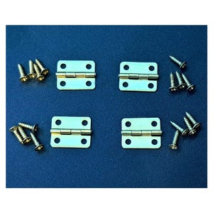 May include: Four gold-toned metal hinges with four sets of screws. The hinges are square-shaped with rounded corners and have a simple design.