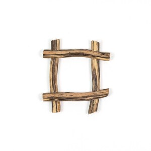 May include: A square frame constructed from four pieces of natural wood arranged in a hashtag pattern. The wood features a light tan base color with prominent dark brown grain lines and streaks running horizontally and vertically throughout.