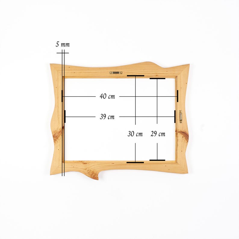 K&ouml;nnte beinhalten: Ein rechteckiger Bilderrahmen aus Holz mit unregelm&auml;&szlig;igem, nat&uuml;rlichem Randdesign. Der Rahmen weist eine sichtbare Holzmaserung und Metallaufh&auml;ngungen auf. Technische Anmerkungen zeigen eine Dicke von 5 mm sowie Innenma&szlig;e von 40 cm mal 30 cm und 39 cm mal 29 cm.
