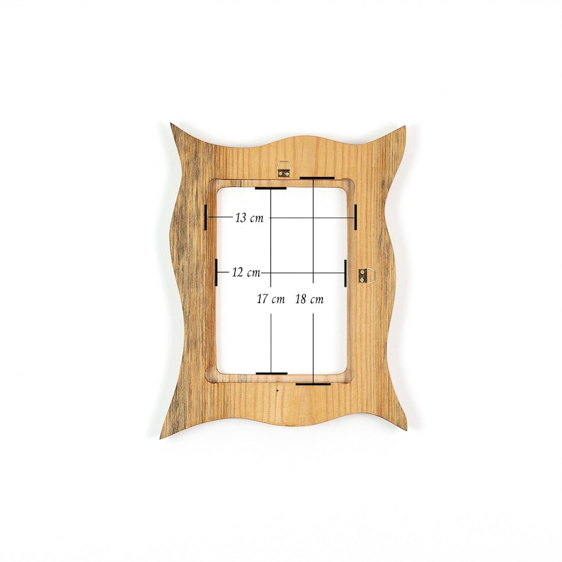 Pu&ograve; includere: Una cornice in legno con un design ondulato unico. L'apertura della cornice misura 17 cm per 12 cm, con dimensioni complessive di 18 cm per 13 cm. La cornice &egrave; in legno chiaro.