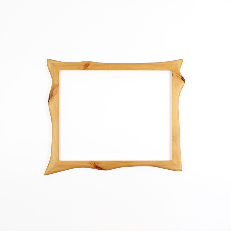 May include: A rectangular picture frame crafted from light-coloured natural wood. The frame features a distinct live edge design on the vertical sides, showcasing visible wood grain patterns and knots throughout the smooth, polished surface.
