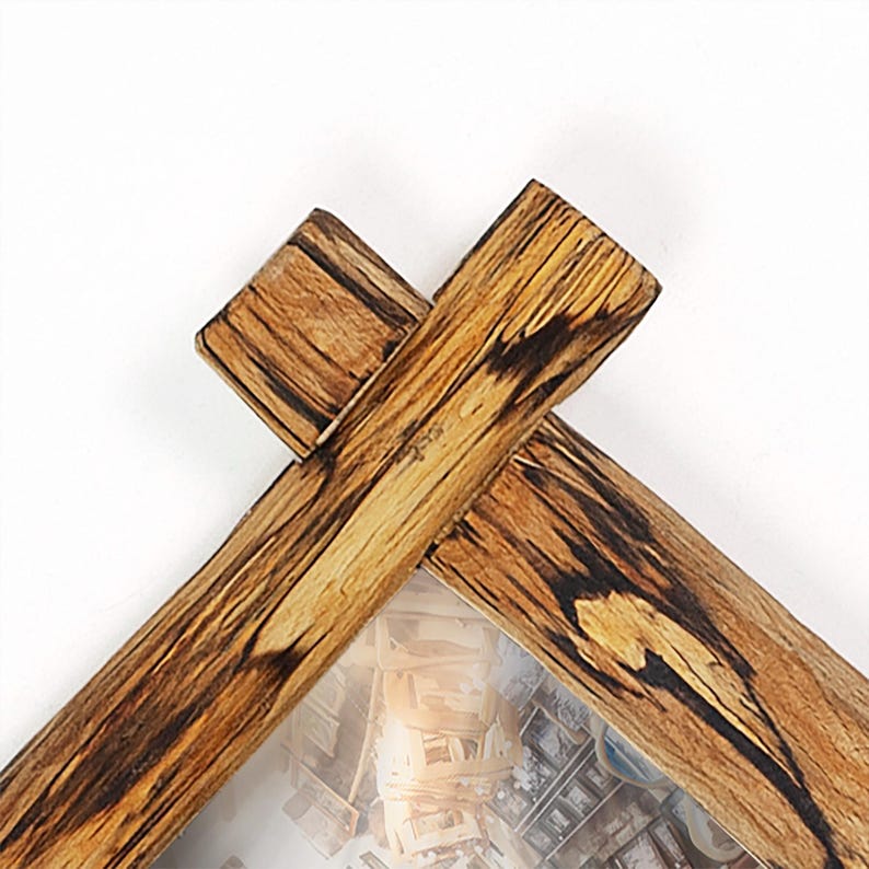 May include: A corner section of a rectangular picture frame constructed from natural wood with a prominent grain pattern. The frame features a lap joint at the corner where two pieces of wood overlap, showcasing dark brown streaks and light tan tones.