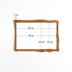 Pu&ograve; includere: Una cornice in legno con un bordo decorativo e ondulato. La cornice &egrave; spessa 5 mm e misura 60 cm di altezza per 40 cm di larghezza. Le dimensioni interne della cornice sono 59 cm per 39 cm.