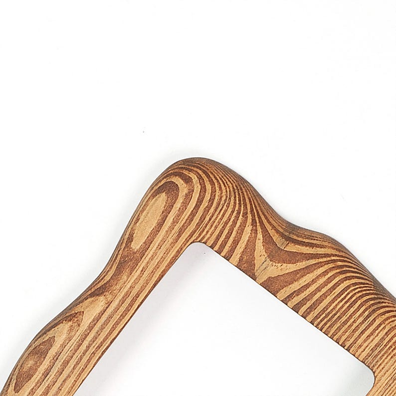 Peut inclure: Un cadre en bois incurv&eacute; pr&eacute;sentant un motif de grain naturel prononc&eacute; avec des tons de bois alternant entre le beige clair et le brun fonc&eacute;. Le cadre poss&egrave;de un bord arrondi lisse et une ouverture rectangulaire, r&eacute;v&eacute;lant la texture organique.