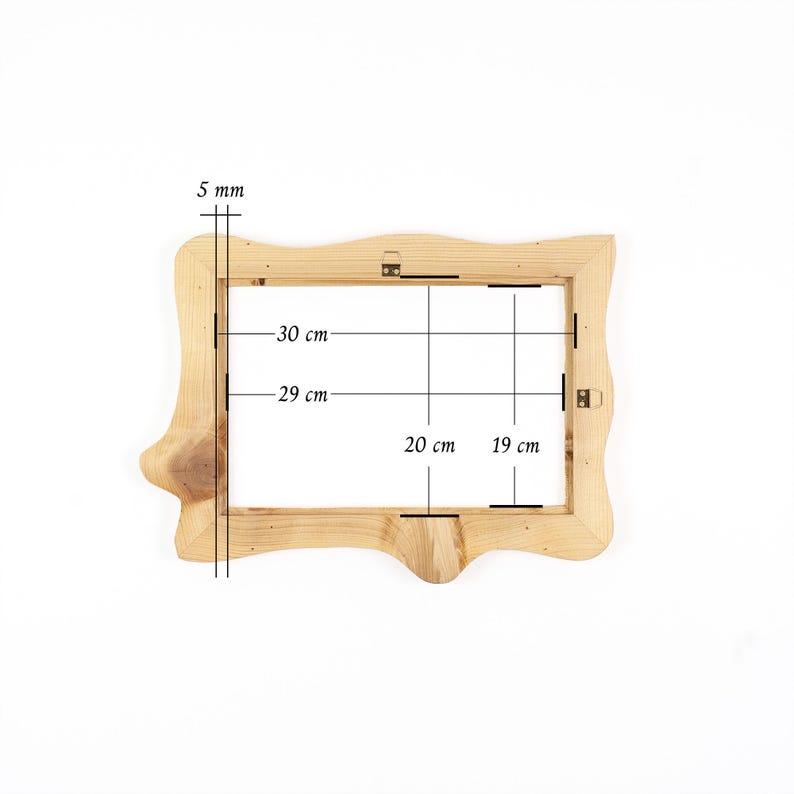 Puede incluir: Un marco de fotos de madera natural clara con un borde org&aacute;nico irregular. El marco presenta vetas de madera visibles y herrajes met&aacute;licos para colgar. Las anotaciones t&eacute;cnicas indican un grosor de 5 mm, con dimensiones internas de 29 cm por 19 cm y externas de 30 cm por 20 cm.