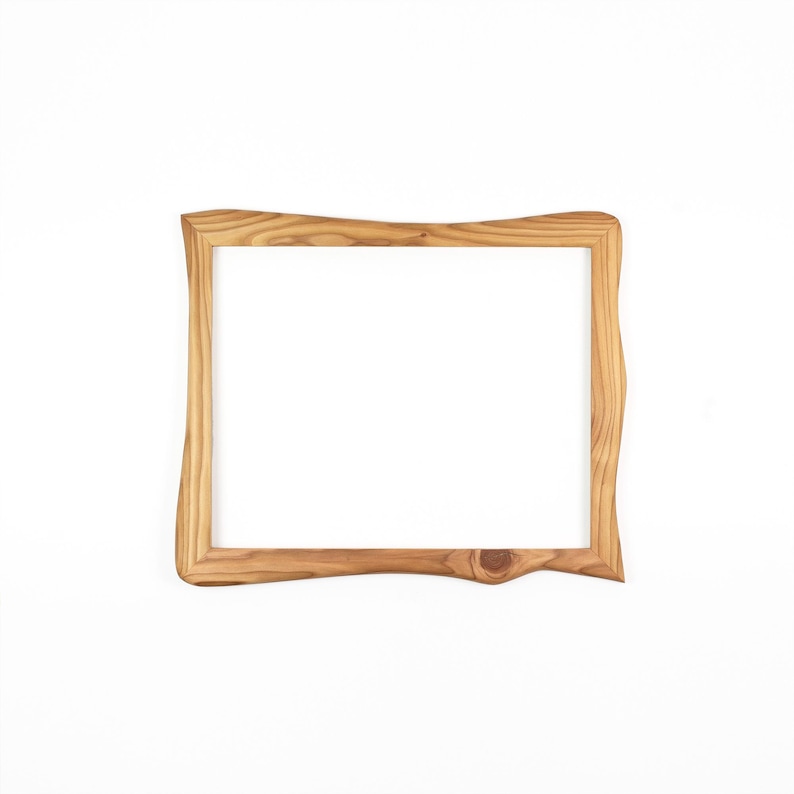 May include: A rectangular wooden picture frame featuring a natural light brown finish with visible wood grain patterns. The frame has an irregular, wavy outer edge and a smooth inner border, showcasing the organic texture of the wood material.