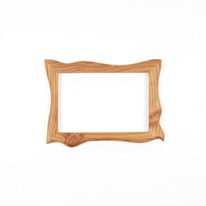 May include: A rectangular wooden picture frame featuring a natural light brown wood grain pattern. The frame has an irregular, wavy outer edge and a prominent circular wood knot detail on the bottom left corner of the frame border.