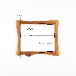 Op de afbeelding: Een houten fotolijst met een natuurlijke afwerking. De lijst heeft een onregelmatige, gebogen vorm en meet intern 30 cm bij 29 cm. De lijst is 5 mm dik en heeft metalen ophangbeugels.