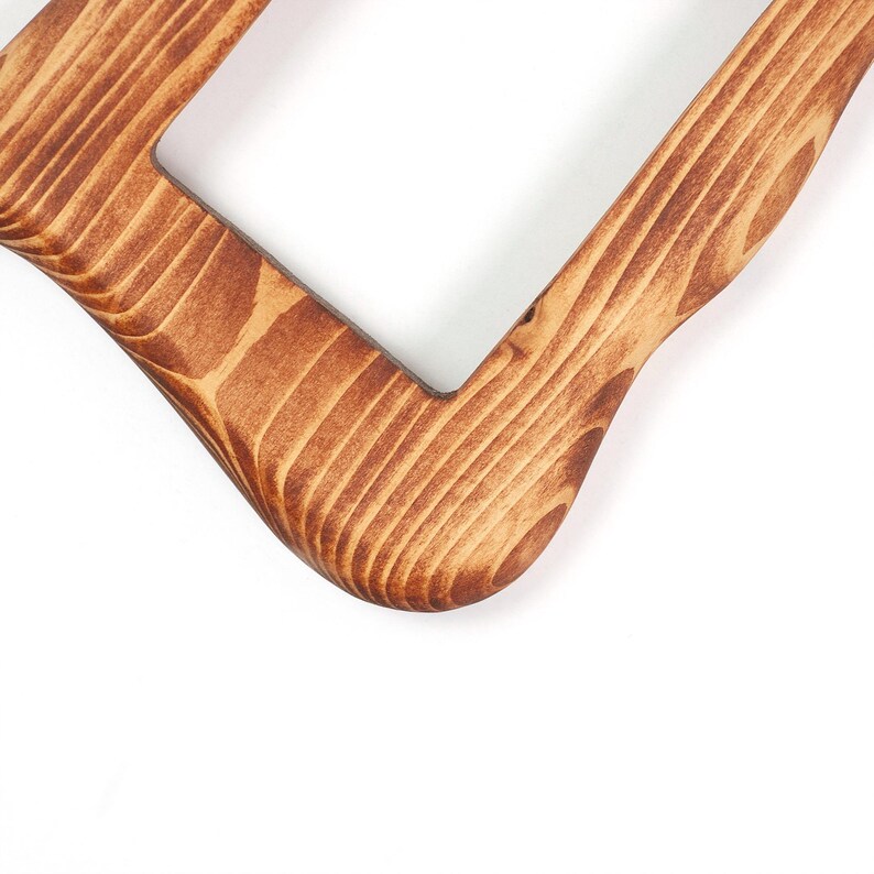 Peut inclure: Un cadre rectangulaire en bois pr&eacute;sentant un motif de grain naturel prononc&eacute; avec des stries brun fonc&eacute; et des tons beige clair. Le cadre poss&egrave;de des coins arrondis et une finition lisse et polie, mettant en valeur la texture du bois.