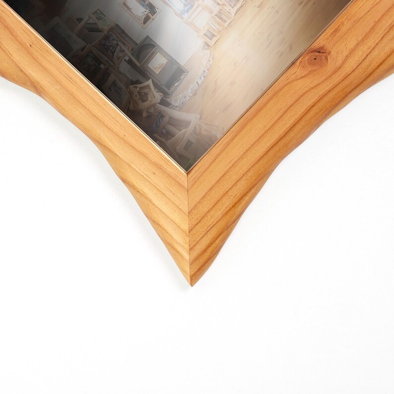 Pu&ograve; includere: Una cornice portafoto in legno marrone chiaro con un caratteristico design a forma di stella a cinque punte. La cornice presenta una texture naturale con venature del legno e una finitura liscia, circondando un vetro trasparente che mostra una foto.