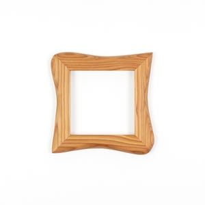 May include: A square wooden picture frame with a light brown finish. The frame has a unique, wavy design on the outer edges, giving it a natural, organic look. The frame is empty, ready to hold a photograph or artwork.