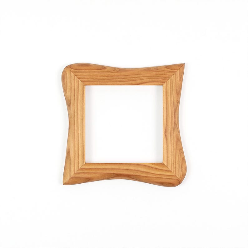 May include: A square wooden picture frame with a light brown finish. The frame has a unique, wavy design on the outer edges, giving it a natural, organic look. The frame is empty, ready to hold a photograph or artwork.