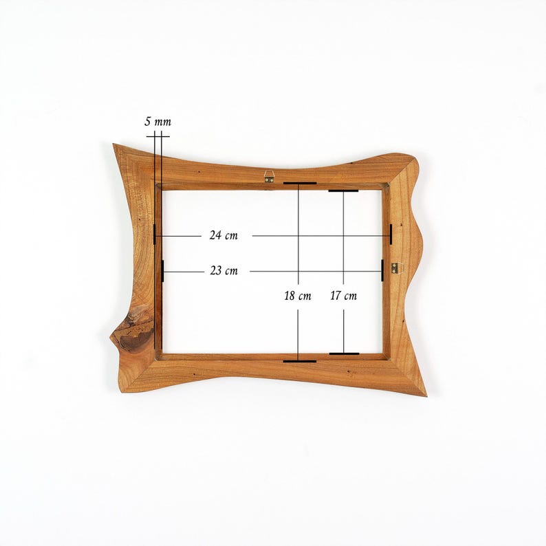 Puede incluir: Un marco de fotos de madera natural con un borde exterior irregular y ondulado. El marco tiene dimensiones internas de 24 cm por 18 cm y 23 cm por 17 cm, con un grosor de 5 mm. Un soporte met&aacute;lico para colgar est&aacute; fijado en la parte superior.