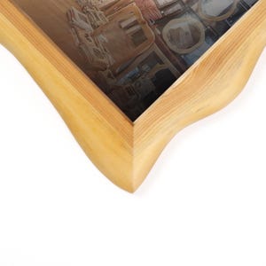 Peut inclure: Un cadre photo en bois clair avec un design incurv&eacute; unique. Le cadre pr&eacute;sente un grain de bois naturel et une finition lisse. L'image &agrave; l'int&eacute;rieur du cadre est une photographie d'une pi&egrave;ce avec des meubles.