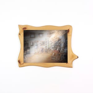 Peut inclure: Un cadre photo en bois clair avec un design de bord unique et ondul&eacute;. Le cadre contient une image miroir d'une pi&egrave;ce remplie d'&oelig;uvres d'art et d'autres cadres. Le cadre est pos&eacute; sur un fond blanc.