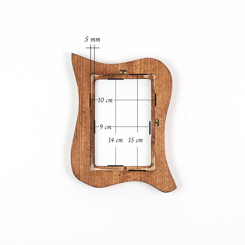 May include: A brown wooden picture frame with a distinctive, curved shape. The frame is 5 mm thick. The internal dimensions are 9 cm by 15 cm. The frame is designed to hold a 10 cm by 14 cm photo.