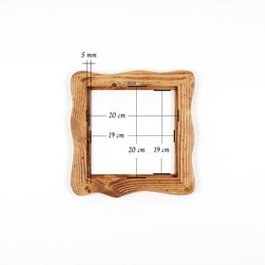 K&ouml;nnte beinhalten: Ein quadratischer Holzbilderrahmen mit gewelltem Rand. Der Rahmen misst 20 cm x 19 cm und ist 5 mm dick. Der Rahmen besteht aus hellbraunem Holz und hat eine nat&uuml;rliche Holzmaserung.