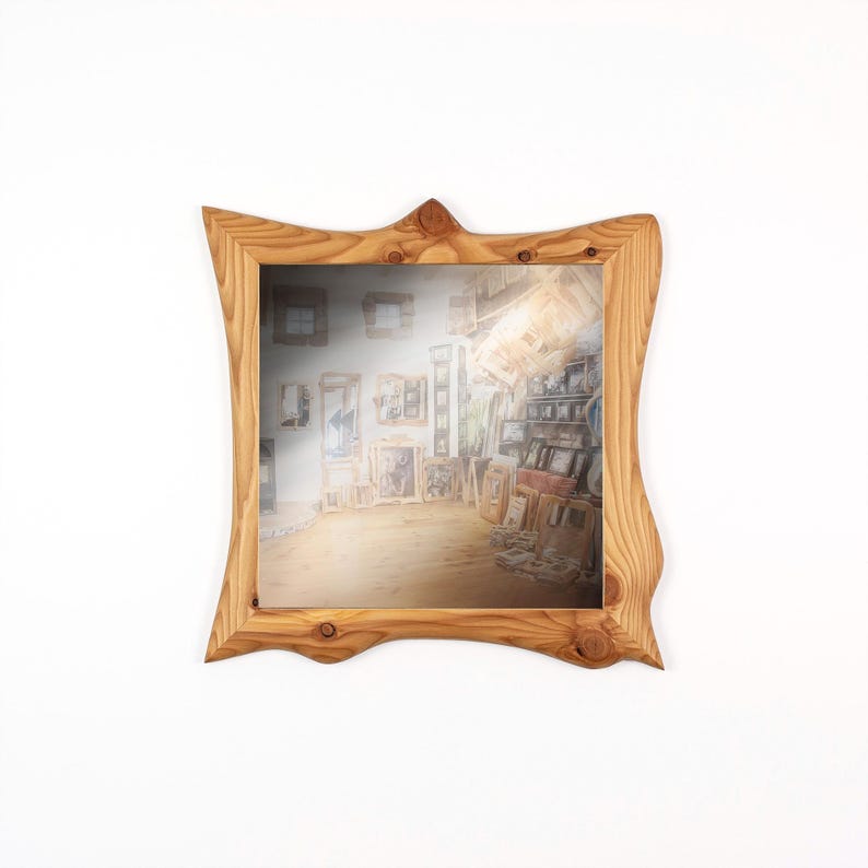 May include: A square wooden mirror with a natural wood grain finish. The frame has a unique, wavy design. The mirror reflects a room filled with framed artwork, creating a gallery-like effect. The wood has a warm, light brown color.