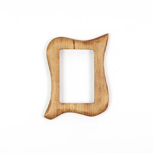 May include: A wooden picture frame with a distinctive, undulating shape. The frame is rectangular with a central aperture and is crafted from light brown wood. The edges have a slightly weathered appearance, enhancing its rustic appeal.
