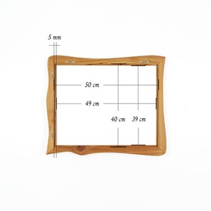 May include: A rectangular wooden picture frame with wavy, organic edges. The frame features metal hanging hardware on the back. Technical annotations indicate dimensions of 50 cm by 40 cm for the outer edge and 49 cm by 39 cm for the inner opening, with a 5 mm thickness.