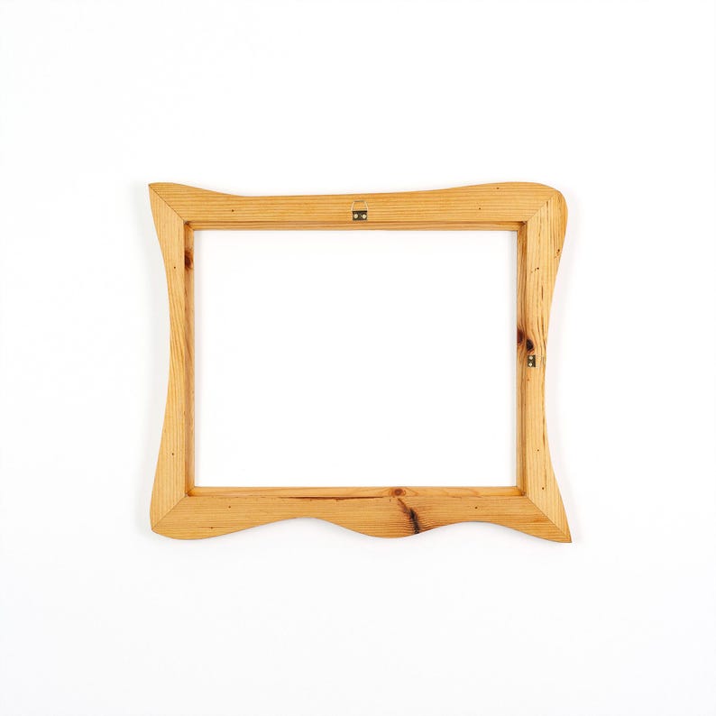 May include: A rectangular wooden picture frame with a natural light brown finish and visible wood grain. The frame features a distinct wavy, curved edge design on the top and bottom sides, and includes a small metal hanging bracket on the back.