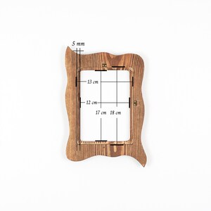 Peut inclure: Un cadre photo rectangulaire en bois avec un bord ext&eacute;rieur ondul&eacute; et irr&eacute;gulier et une finition en grain de bois brun naturel. Le cadre pr&eacute;sente des dimensions int&eacute;rieures de 13 cm sur 17 cm, des dimensions ext&eacute;rieures de 18 cm sur 12 cm et une &eacute;paisseur de 5 mm.