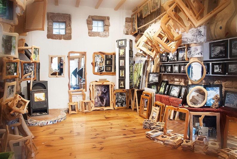 Peut inclure: Une galerie d'art rustique pr&eacute;sentant des &oelig;uvres encadr&eacute;es et des miroirs avec des cadres en bois naturel. L'espace a une atmosph&egrave;re chaleureuse avec des planchers en bois et une vari&eacute;t&eacute; de pi&egrave;ces encadr&eacute;es, dont des paysages et des animaux.