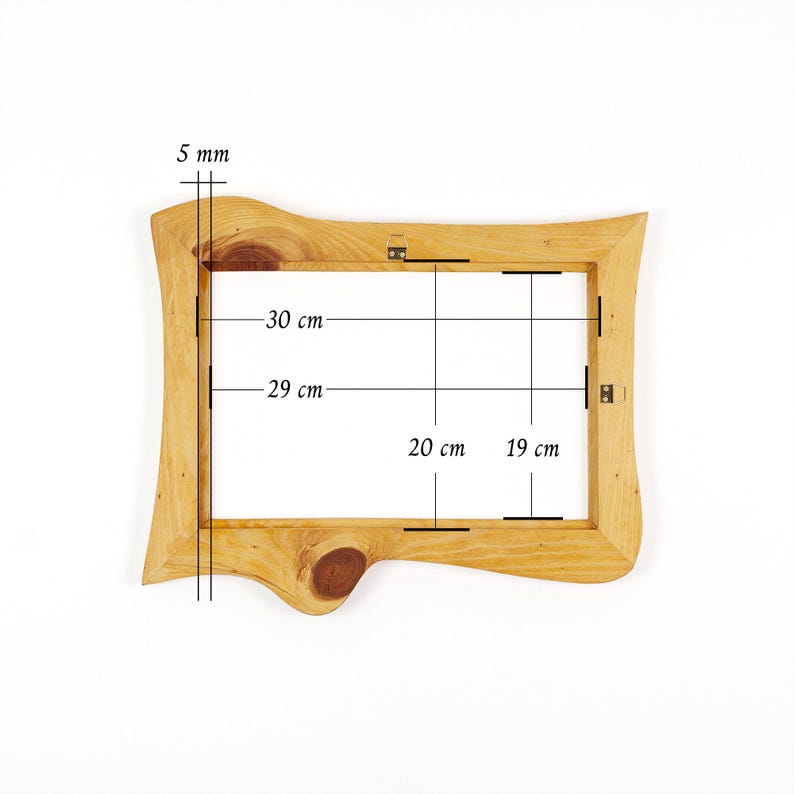 Puede incluir: Un marco de fotos de madera de color marr&oacute;n claro con un borde natural y veta visible. El marco cuenta con herrajes met&aacute;licos para colgar en la parte posterior. Las anotaciones t&eacute;cnicas indican un grosor de 5 mm y medidas internas de 30 cm por 20 cm.