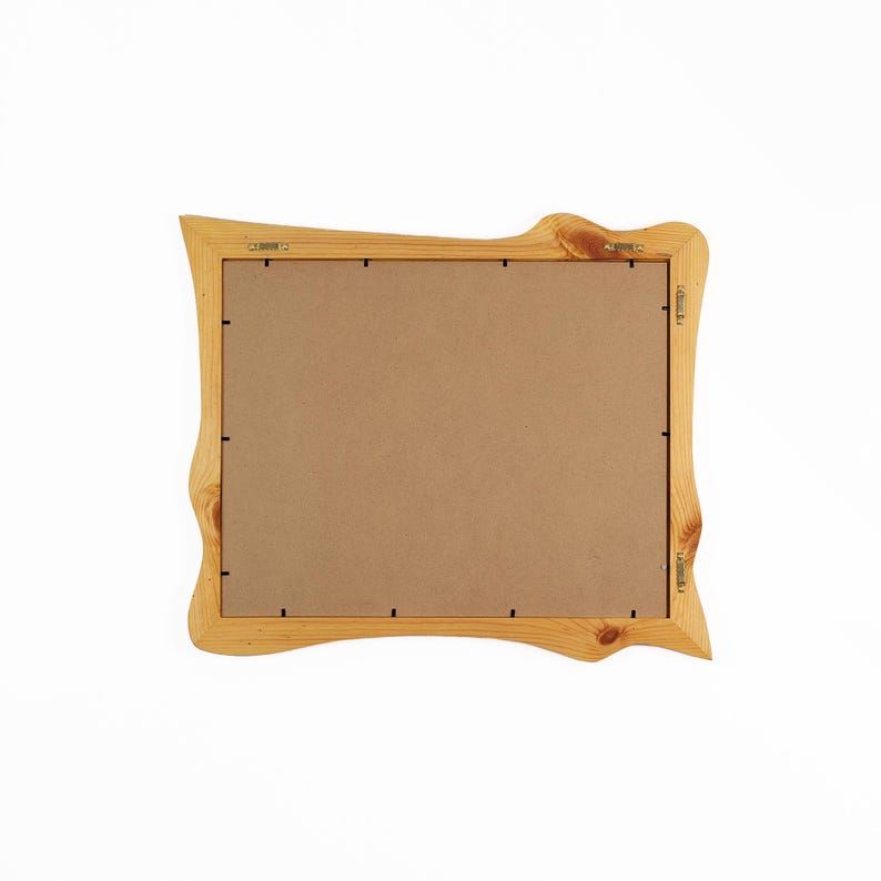 K&ouml;nnte beinhalten: Ein hellfarbiger Holzbilderrahmen mit einem einzigartigen, wellenf&ouml;rmigen Design. Der Rahmen hat eine nat&uuml;rliche Holzmaserung und eine braune R&uuml;ckseite. Der Rahmen ist mit Metallbeschl&auml;gen auf der R&uuml;ckseite zum Aufh&auml;ngen bereit.