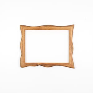 May include: A rectangular wooden picture frame with a wavy, organic edge design. The frame is made of light brown wood and has a natural finish. The frame is empty, with a white background visible through the opening.