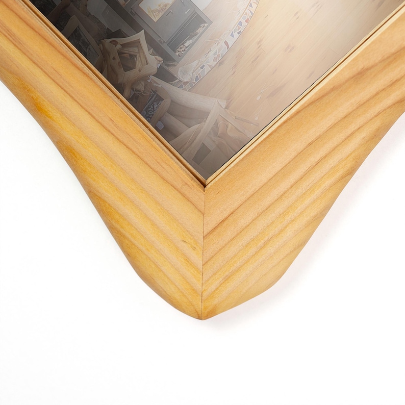 Peut inclure: Un cadre photo en bois brun clair avec une texture nervur&eacute;e ou cannel&eacute;e distincte sur le bord ext&eacute;rieur. Le cadre pr&eacute;sente un assemblage &agrave; onglet et contient une vitre transparente refl&eacute;tant l'int&eacute;rieur d'une pi&egrave;ce avec une chemin&eacute;e.