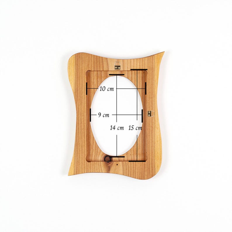 May include: A wooden picture frame with an oval opening. The frame is light brown and has a wavy, decorative edge. The opening dimensions are 9 cm x 14 cm, and the overall frame dimensions are 10 cm x 15 cm.