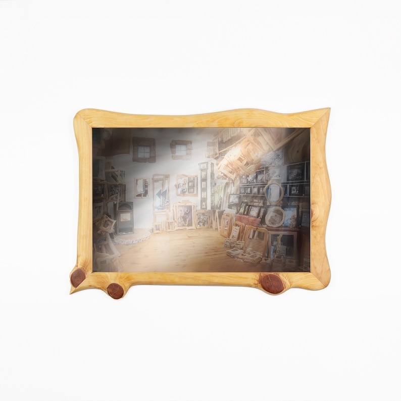May include: A rectangular picture frame crafted from light-colored natural wood with an irregular, wavy edge and two prominent dark knots on the bottom border. The frame contains a print depicting an interior room filled with various framed art.