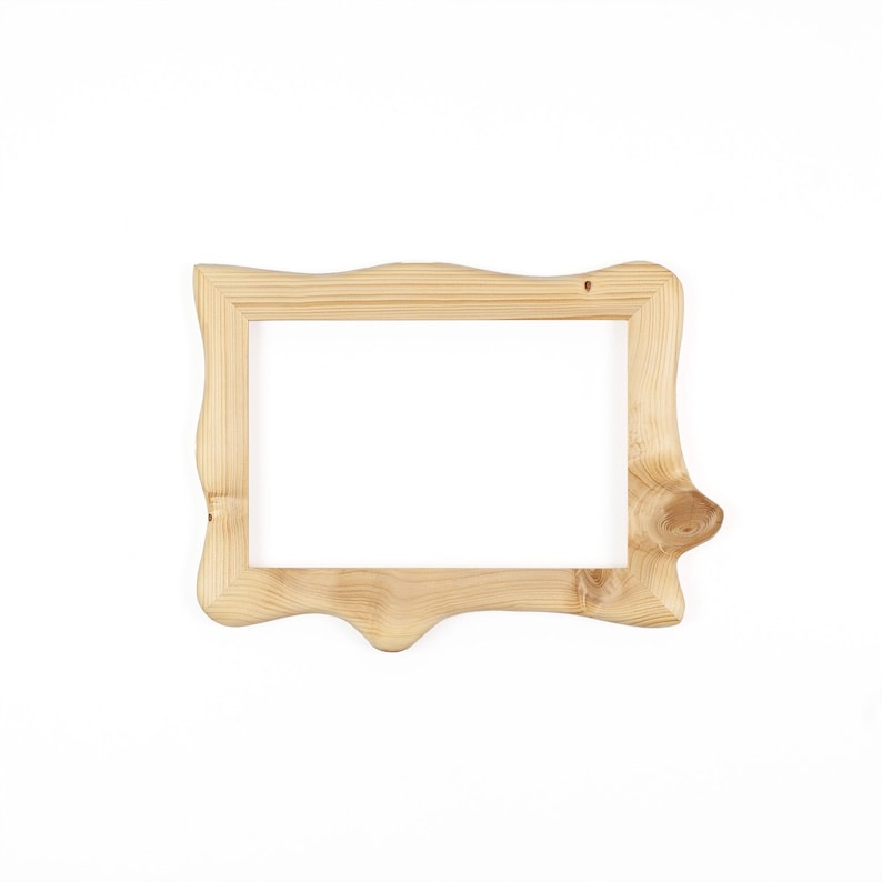 Puede incluir: Un marco de fotos rectangular hecho de madera natural de color claro con un patr&oacute;n de veta visible. El marco presenta un borde exterior org&aacute;nico e irregular con un contorno suave y redondeado y un detalle de nudo prominente en el lado derecho.