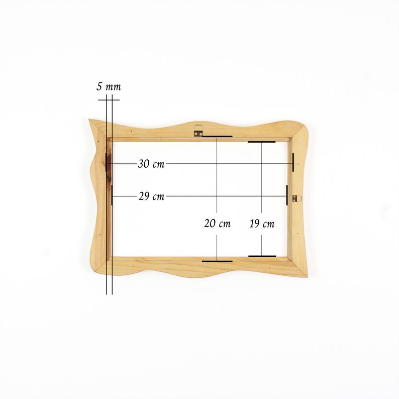 May include: A light-coloured wooden picture frame with wavy outer edges. The frame features technical markings indicating dimensions of 30 cm by 20 cm, an inner opening of 29 cm by 19 cm, and a frame thickness of 5 mm, with metal hanging hardware.