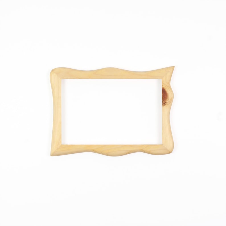May include: A rectangular wooden picture frame with a light tan natural wood grain finish. The frame features a wavy, organic edge design along the top and bottom borders, and a visible dark wood knot detail on the right side of the frame.