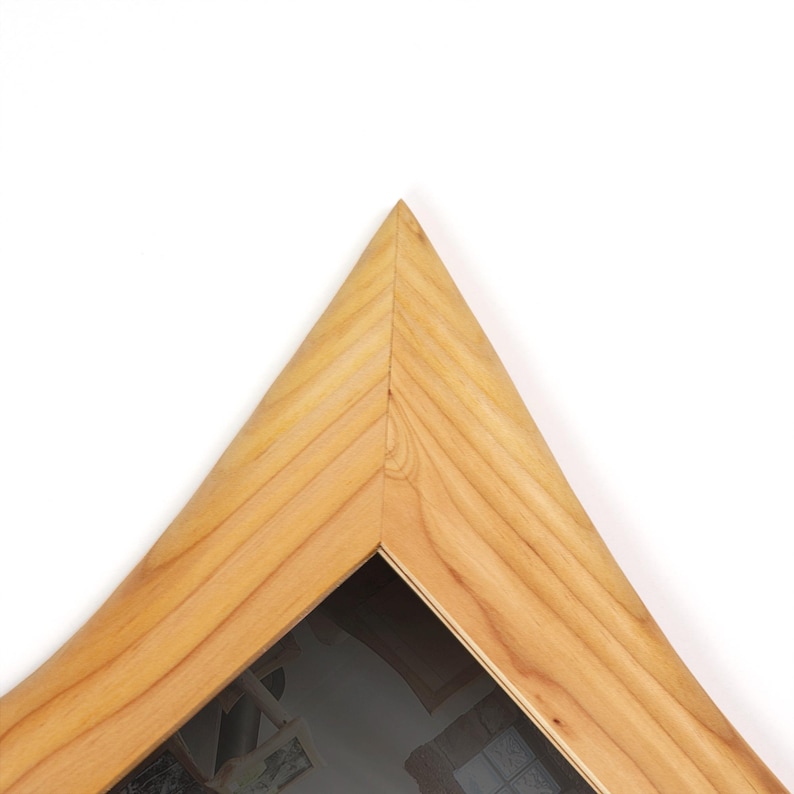 Peut inclure: Un cadre photo triangulaire en bois avec une finition en grain de bois naturel brun clair. Le cadre est construit avec des joints &agrave; onglet se rejoignant en une pointe sup&eacute;rieure ac&eacute;r&eacute;e, cr&eacute;ant une forme g&eacute;om&eacute;trique &agrave; la surface lisse.