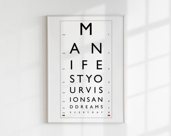 Puede incluir: Impresión enmarcada de una tabla optométrica con las palabras "Manifiesta tus visiones y sueños todos los días" en negro. La impresión se muestra en una pared blanca.