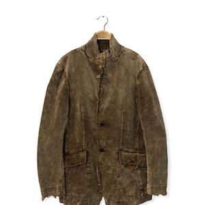 Puede incluir: Un juego de tres tazas de cerámica con acabado moteado y mate. Las tazas son de color crema, gris claro y gris oscuro. Cada taza tiene un diseño simple y minimalista.