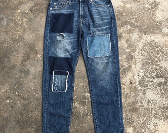 Calça jeans vintage Global Work Jeans, desbotada e com patchwork, na cor azul.