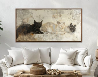 以下が含まれることがあります： 白い背景に3匹の猫が寝ている絵画。猫は黒猫、白猫、灰色猫。絵画は茶色の額縁に収められ、白い壁に白いソファの上に飾られている。