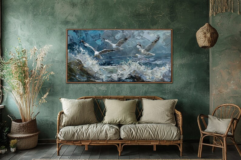 Puede incluir: Una pintura enmarcada de tres gaviotas volando sobre un mar tormentoso con olas blancas. La pintura est&aacute; en un marco de madera y est&aacute; colgada en una pared verde.